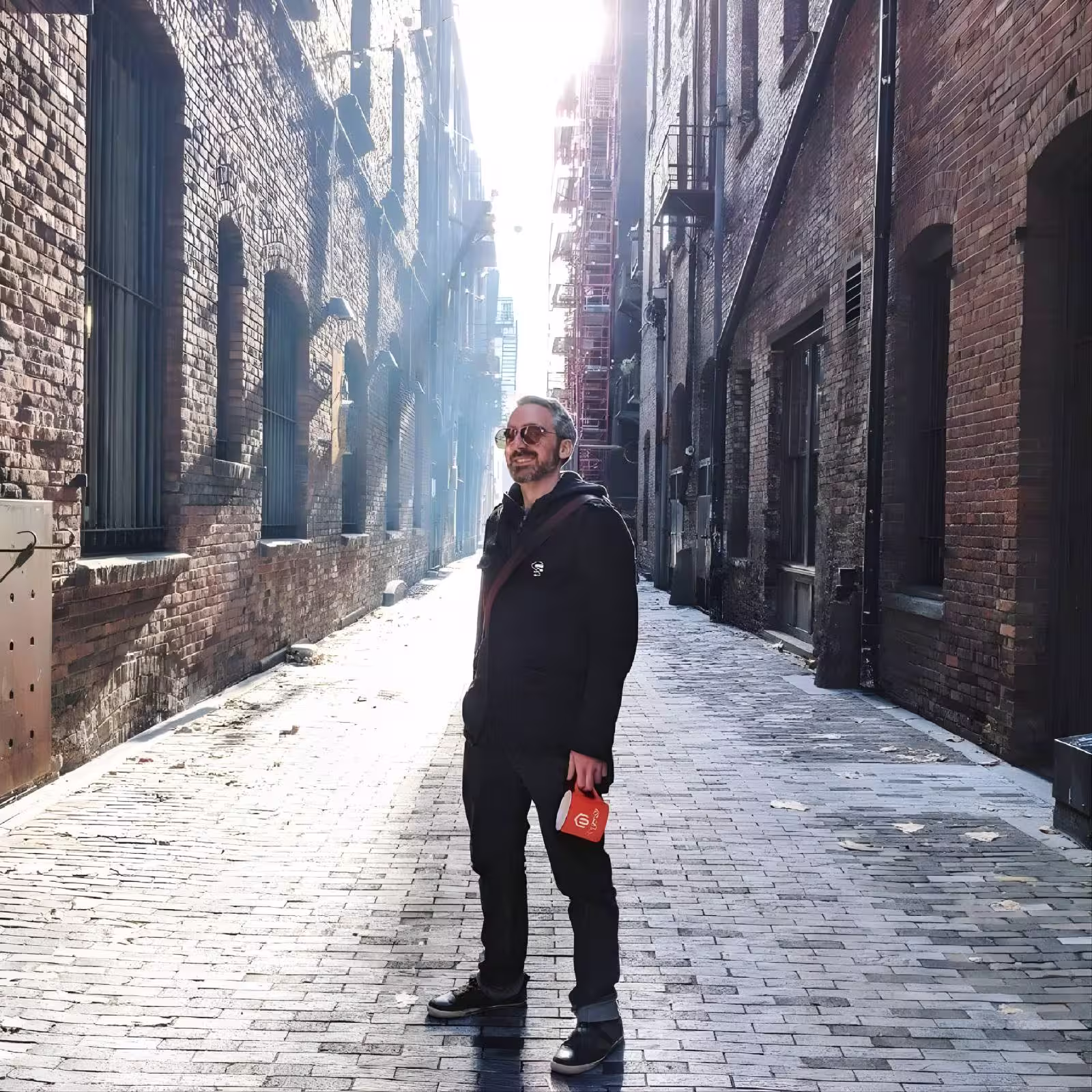 A photo of Daniel smiling in an alleyway